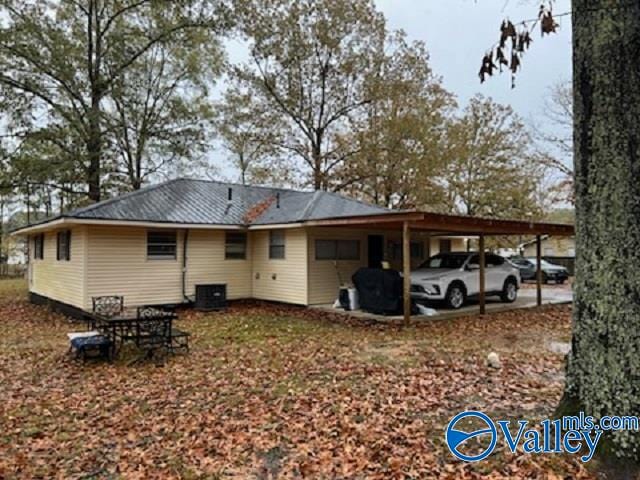 rear view of property featuring a carport and central AC unit