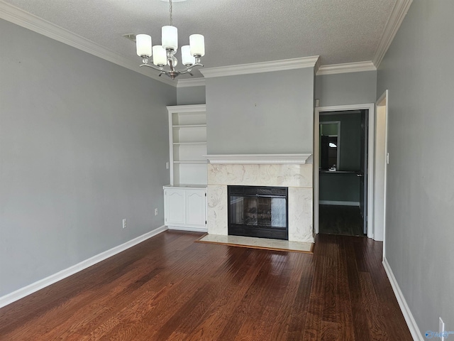 unfurnished living room with a fireplace, baseboards, a chandelier, and wood finished floors