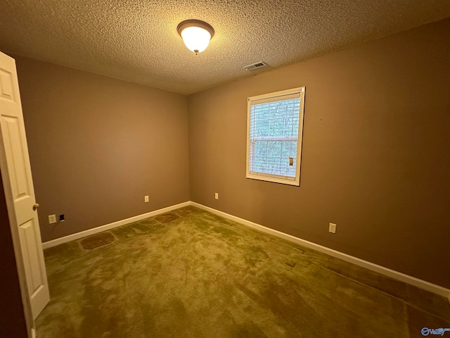 spare room featuring carpet flooring and a textured ceiling