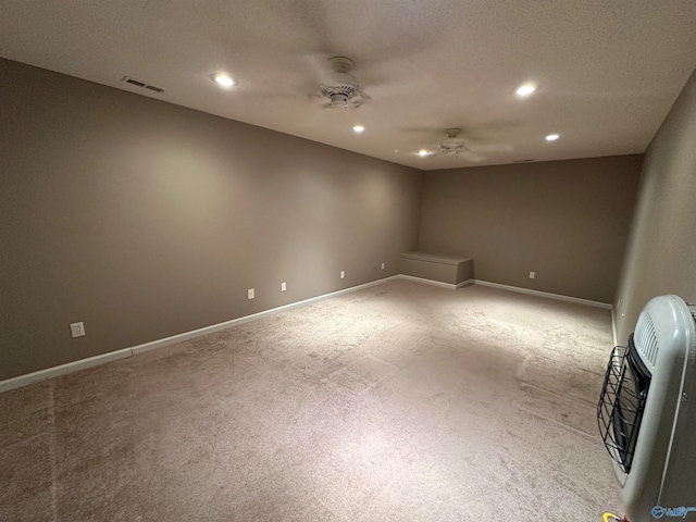 carpeted spare room with ceiling fan, a textured ceiling, and heating unit