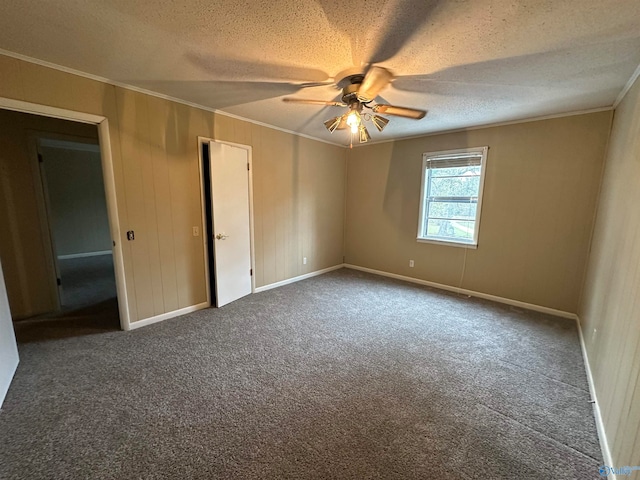 spare room with a textured ceiling, carpet floors, ceiling fan, and ornamental molding