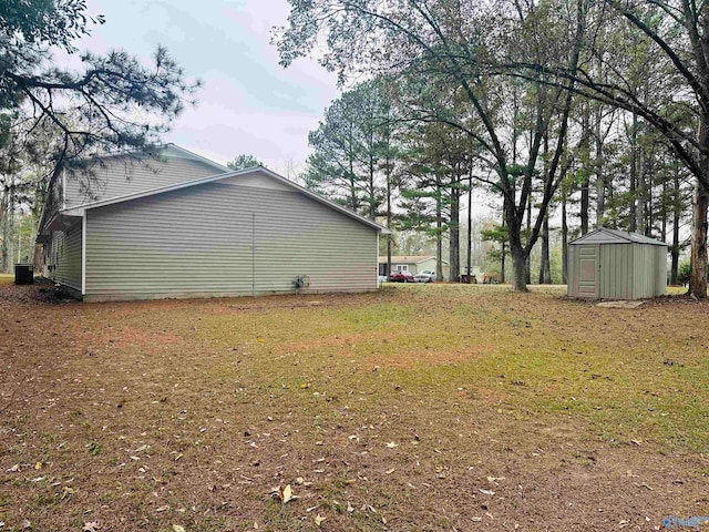 view of side of home with a lawn and a shed