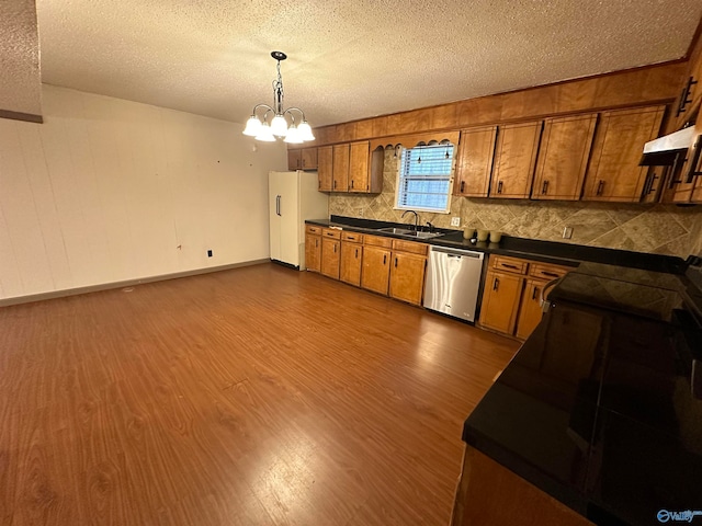 kitchen featuring dishwasher, a textured ceiling, dark hardwood / wood-style flooring, and backsplash