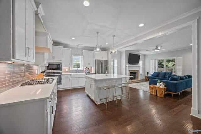 2654 Mountain Stream Way, Owens Cross Roads, AL 35763 - kitchen featuring stainless steel appliances, a glass covered fireplace, a ceiling fan, light countertops, and tasteful backsplash