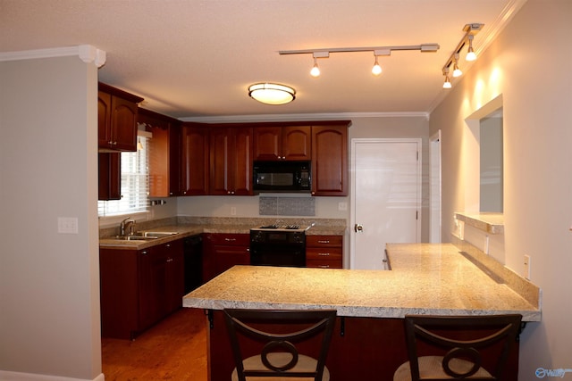 kitchen featuring sink, a kitchen breakfast bar, black appliances, and kitchen peninsula