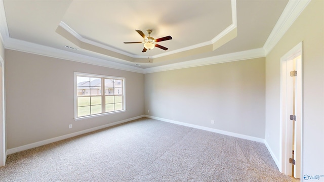 spare room featuring carpet flooring, ceiling fan, crown molding, and a tray ceiling