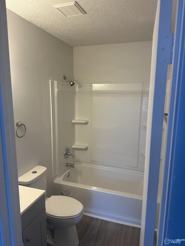full bath featuring wood finished floors, a textured ceiling, vanity, and visible vents