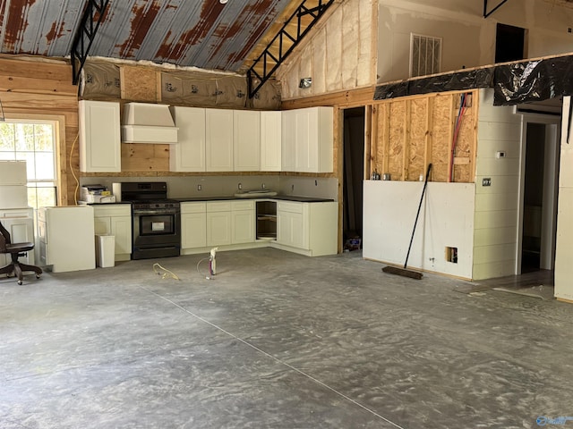 kitchen with custom range hood, black gas stove, concrete floors, a high ceiling, and dark countertops