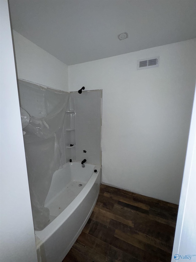 full bath with visible vents, wood finished floors, and washtub / shower combination