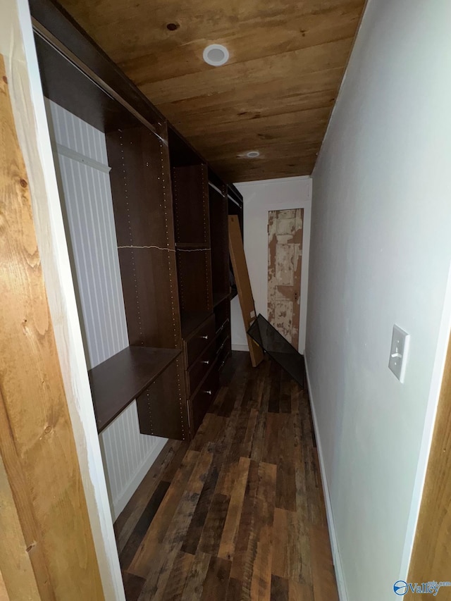 hall featuring wooden ceiling, baseboards, and dark wood-style floors