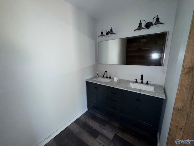 bathroom featuring double vanity, a sink, and wood finished floors