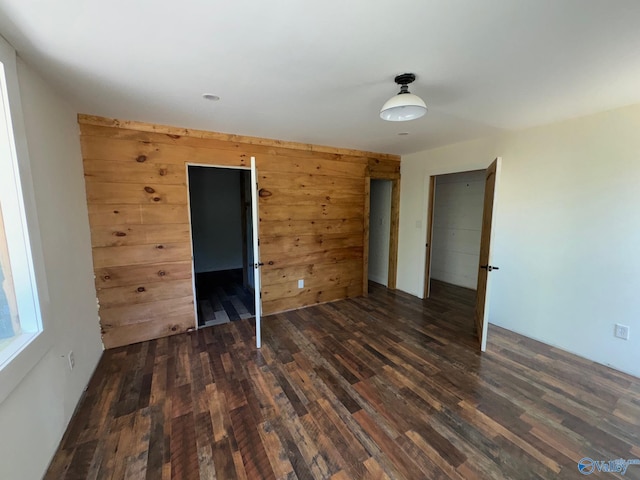 unfurnished bedroom with wooden walls and wood finished floors
