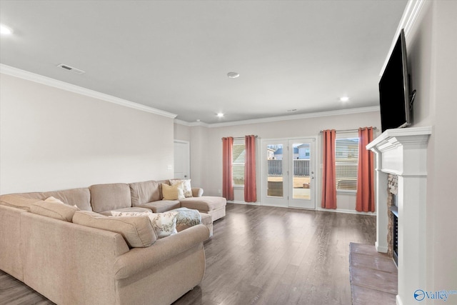 living room with a fireplace, crown molding, and wood-type flooring