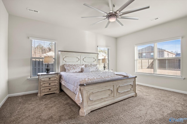 bedroom featuring multiple windows, ceiling fan, and dark colored carpet