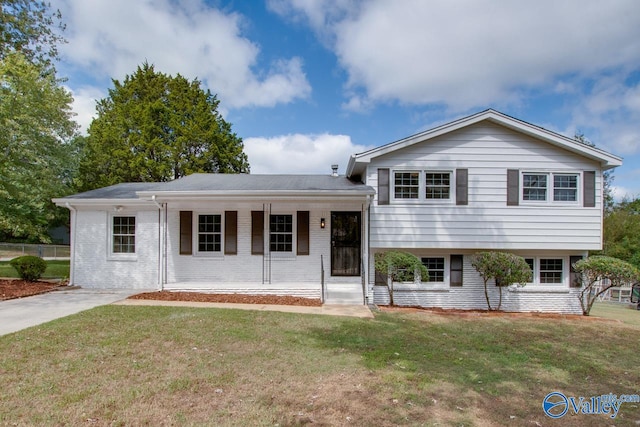 tri-level home with a porch and a front lawn