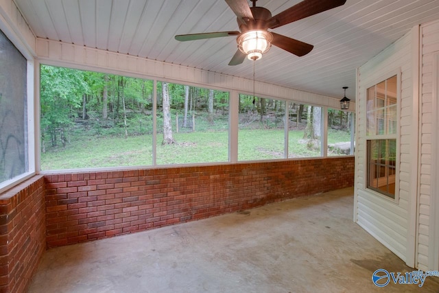 unfurnished sunroom featuring a ceiling fan and a healthy amount of sunlight