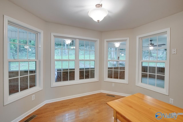 unfurnished dining area with plenty of natural light, light wood-style flooring, baseboards, and visible vents