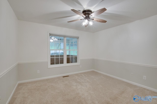 spare room with carpet flooring, a ceiling fan, baseboards, and visible vents