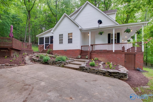 view of front of property with stairs, a sunroom, and a porch