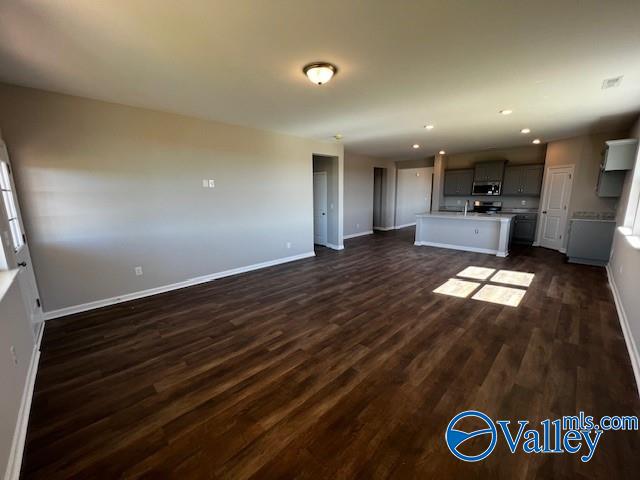 unfurnished living room with dark wood-type flooring