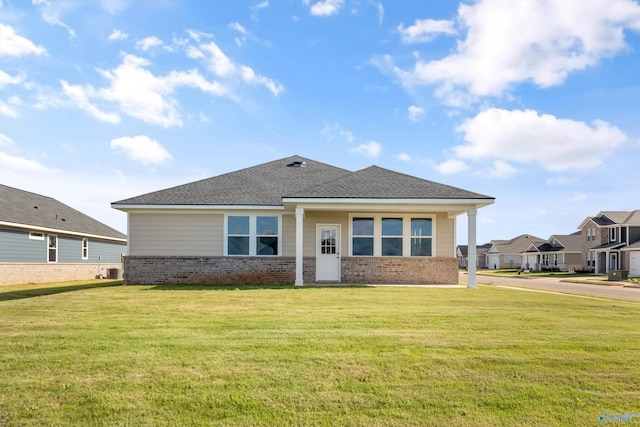 view of front of home with a front yard and central AC