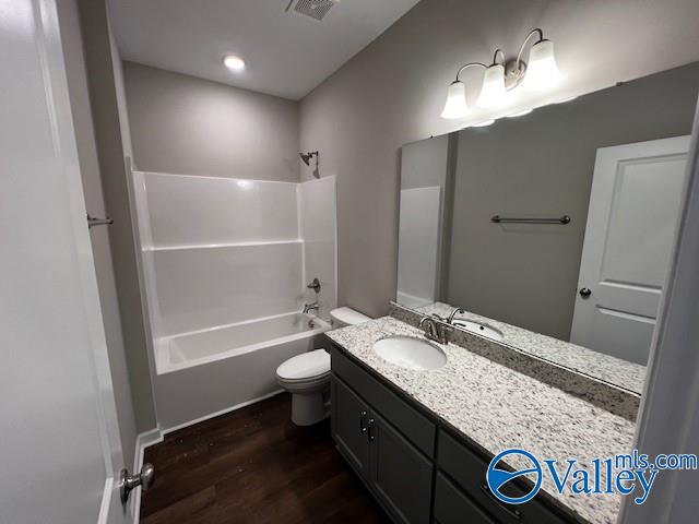 full bathroom with shower / bathing tub combination, vanity, hardwood / wood-style flooring, and toilet