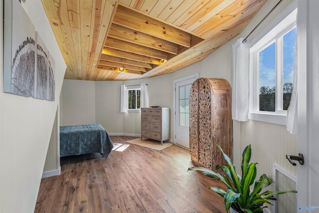 bedroom featuring baseboards, wood finished floors, and wooden ceiling