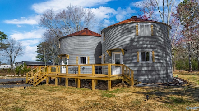 rear view of property featuring stairs and a wooden deck