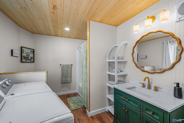 clothes washing area with dark wood-style flooring, independent washer and dryer, wooden ceiling, baseboards, and a sink