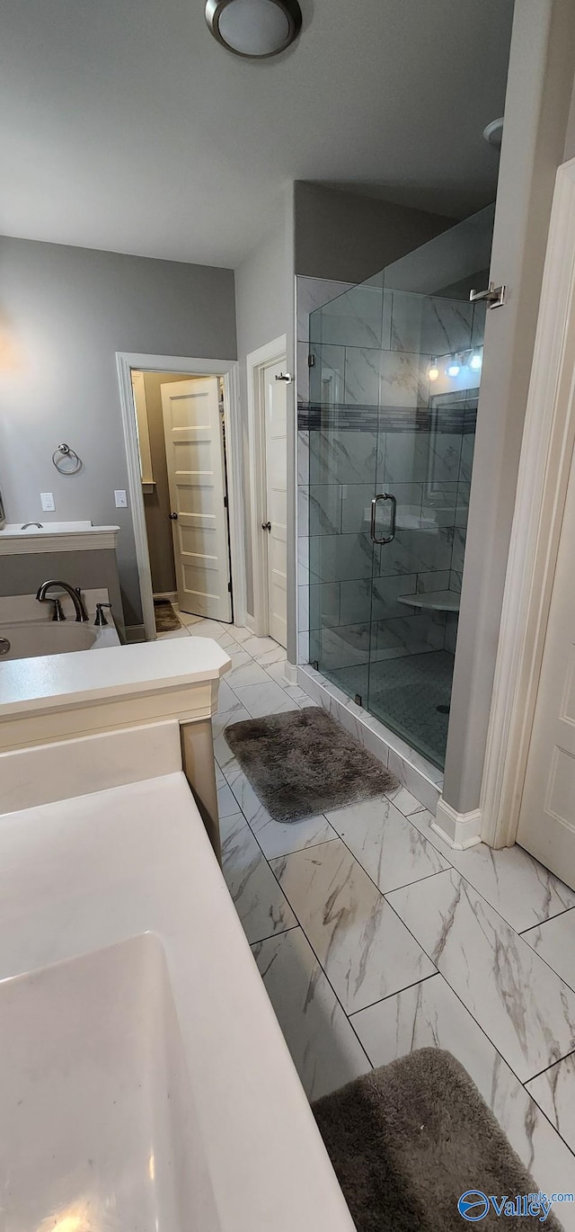 full bath with marble finish floor, a stall shower, and a closet