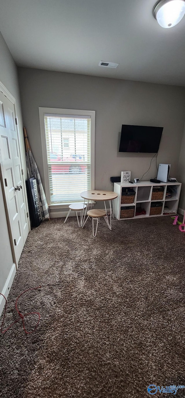 recreation room featuring carpet floors, visible vents, and baseboards