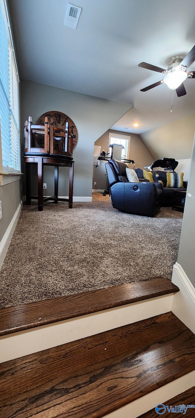 interior space with carpet floors, plenty of natural light, visible vents, and lofted ceiling