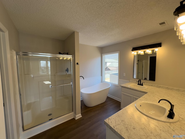 bathroom with a sink, visible vents, a stall shower, and a wainscoted wall