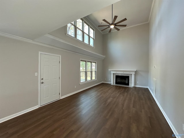 unfurnished living room with dark wood finished floors, crown molding, baseboards, and a high end fireplace