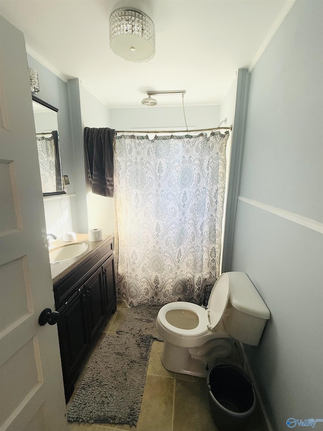 bathroom featuring tile patterned floors, crown molding, vanity, and toilet