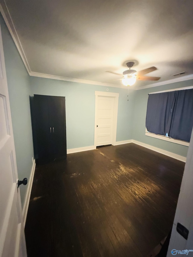 unfurnished room with crown molding and dark wood-type flooring