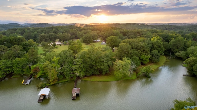 aerial view at dusk featuring a water view