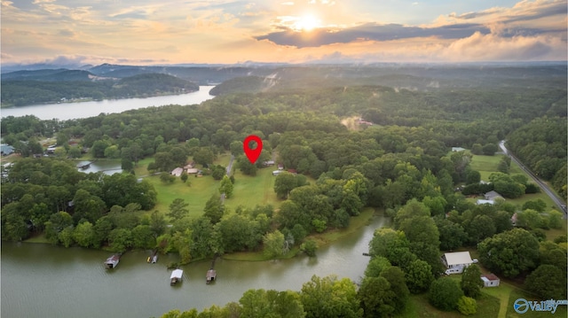 aerial view at dusk featuring a water view