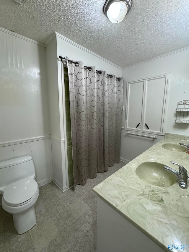 bathroom with a shower with shower curtain, crown molding, toilet, vanity, and a textured ceiling