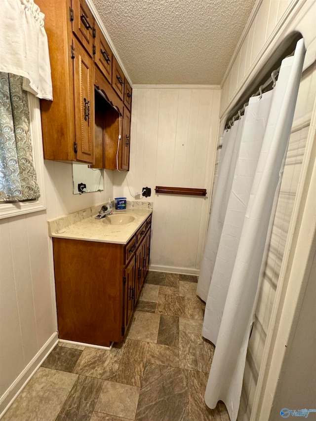 bathroom with wood walls, a textured ceiling, and vanity