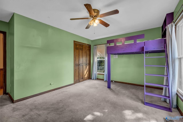 unfurnished bedroom featuring carpet floors, ceiling fan, and a closet