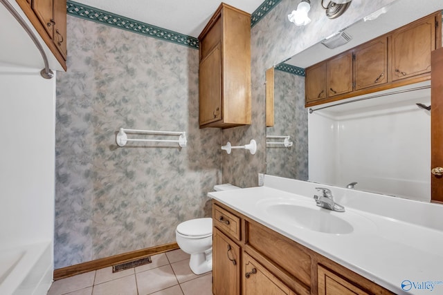 bathroom featuring vanity, a textured ceiling, tile patterned flooring, toilet, and a washtub