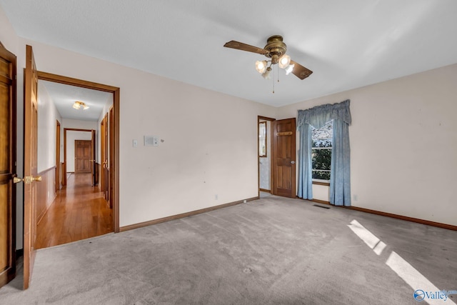 carpeted spare room with ceiling fan