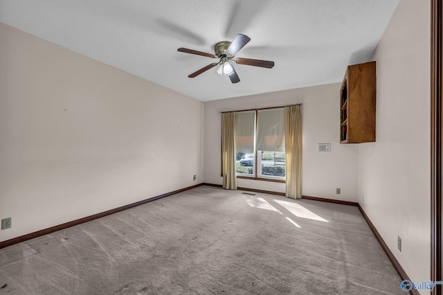 carpeted spare room with a textured ceiling and ceiling fan