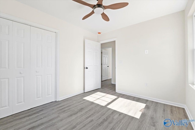 unfurnished bedroom featuring hardwood / wood-style flooring, a closet, and ceiling fan