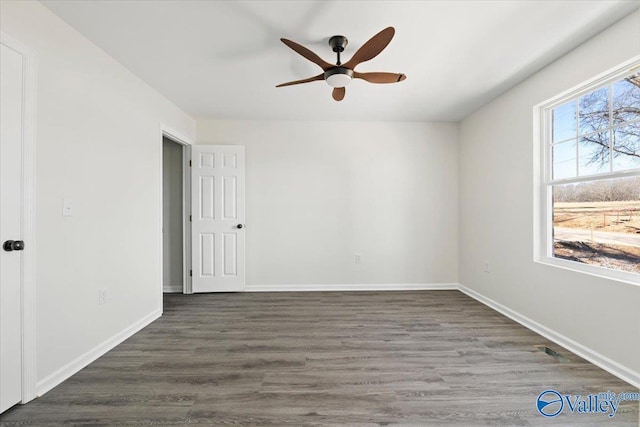 empty room featuring dark wood-type flooring and ceiling fan