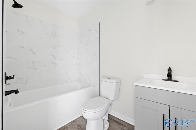 full bathroom with tiled shower / bath, vanity, toilet, and hardwood / wood-style floors