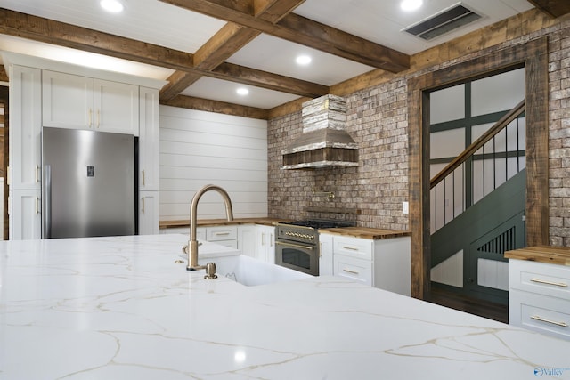 691 County Road 106, Leesburg, AL 35983 - kitchen featuring appliances with stainless steel finishes, wood counters, white cabinets, beam ceiling, and recessed lighting
