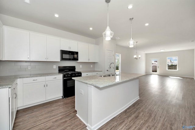 kitchen with pendant lighting, sink, white cabinets, a kitchen island with sink, and black appliances