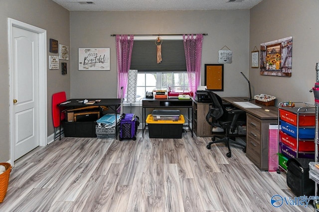 office space with a textured ceiling and light wood-type flooring